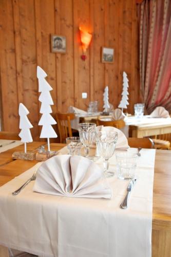 a table with a white table cloth with christmas trees on it at LOGIS Les Arobiers in Lamoura