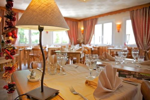 een eetkamer met een tafel met een lamp erop bij Les Arobiers in Lamoura
