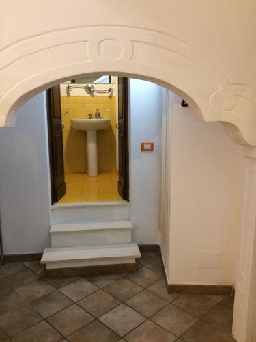a bathroom with an arch with a sink and a mirror at Le Trifore in Ventimiglia