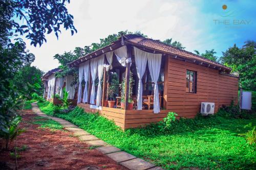 una pequeña casa de madera en medio de un patio en The Bay Agonda, en Agonda