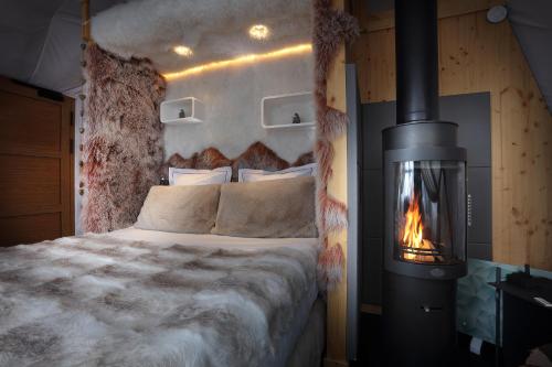 a bedroom with a bed with a fireplace next to it at Hotel Pashmina Le Refuge in Val Thorens