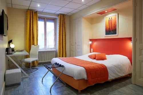 a bedroom with a large bed with an orange headboard at La Commanderie de Champarey in Bourgoin