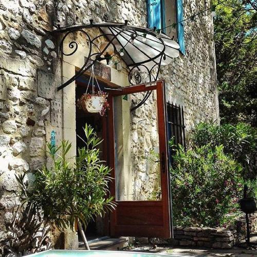 a door to a stone building with a window at Le Mas de Valaurie in Valaurie