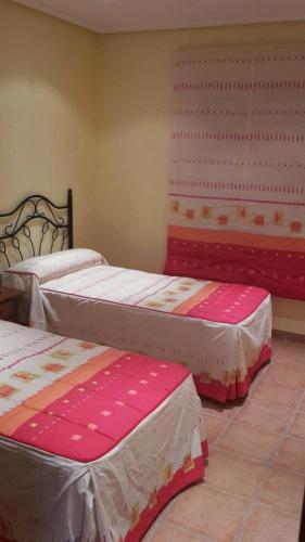three beds in a room with pink and white sheets at Villa Alandalus in Vera