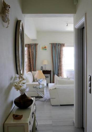 a living room with white furniture and a mirror at Grand Bleu Apartments & Villas in Ermioni