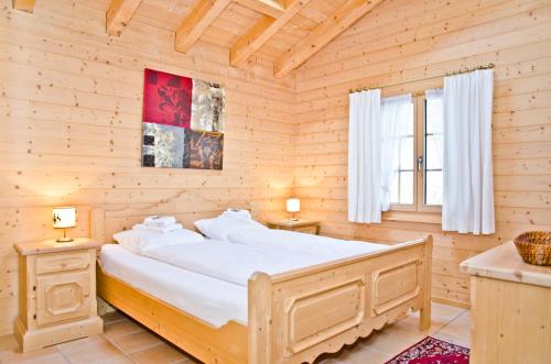 a bedroom with a large bed in a wooden room at Apartment St. Louis 3.5 - GriwaRent AG in Grindelwald