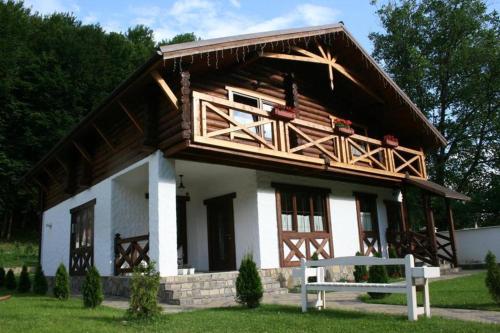 a large wooden house with a bench in front of it at U Druziv in Polyana