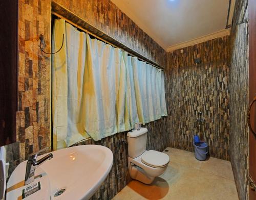 een badkamer met een wit toilet en een wastafel bij Hotel Mahabs in Mahabalipuram
