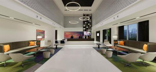 a lobby with couches and chairs in a building at Novotel Kochi Infopark in Cochin