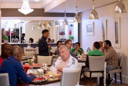 a group of people sitting at tables in a restaurant at Oleander Guest House in Kimberley