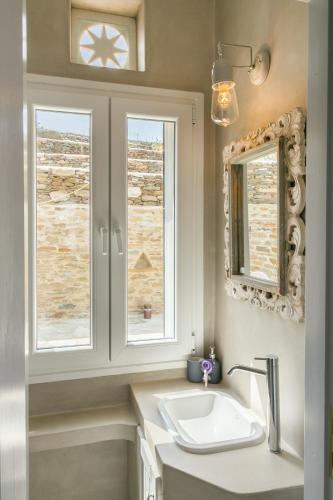 a bathroom with a sink and two windows at Imarkellis Tinos Boutique Villas in Panormos