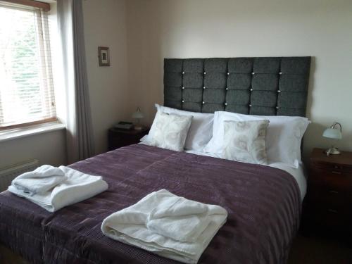 a bedroom with a bed with two towels on it at Hedgehope Cottage Alnwick in Alnwick