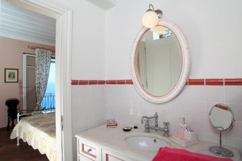 a bathroom with a sink and a mirror at Boutique Villa Andronice in Tsoukaladhes