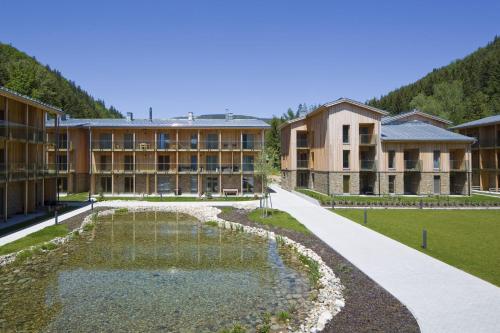 an exterior view of a building with a pond at Apartman Medvědín 307 in Špindlerův Mlýn