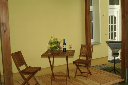 ツィノヴィッツにあるFewo-Ostseewindのテーブル(ワイン1本付)と椅子2脚