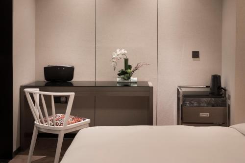 a bedroom with a bed and a desk with a chair at Paco Hotel Dongpu Guanghzou -Free Shuttle Bus for Canton Fair in Guangzhou