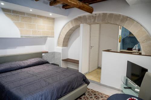 1 dormitorio con 1 cama y TV en Cortile Azzurro en Trapani