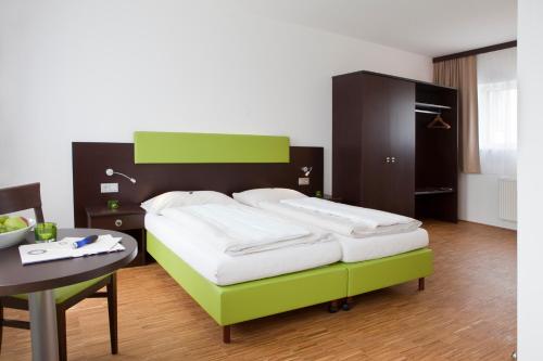 ein Schlafzimmer mit einem Bett mit einem Tisch und einem Tisch in der Unterkunft Stadthotel Waidhofen an der Thaya in Waidhofen an der Thaya