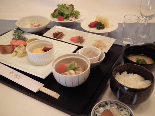 een tafel met borden en kommen met eten erop bij Furano La Terre in Nakafurano