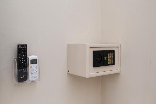 a microwave on a wall with a remote control at TOHOUSE Rooms in Turin