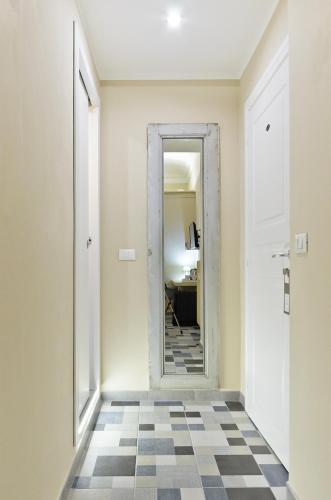 a hallway with a mirror and a checkered floor at TOHOUSE Rooms in Turin