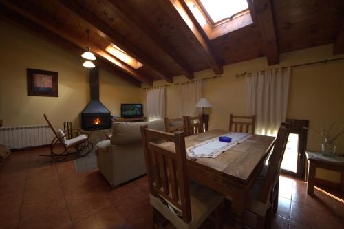 a living room with a table and a couch and a fireplace at Rio La Estrella in Mosqueruela