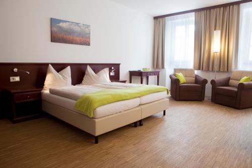 a bedroom with a bed and a couch and a chair at Stadthotel Waidhofen an der Thaya in Waidhofen an der Thaya
