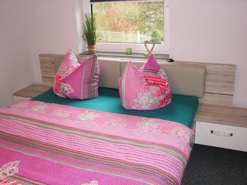 バート・シャンダウにあるWaldidylleのベッドルーム1室(ピンクの枕が置かれたベッド、窓付)
