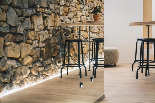 a bar with stools in front of a stone wall at Moyua Apartment by People Rentals in Bilbao