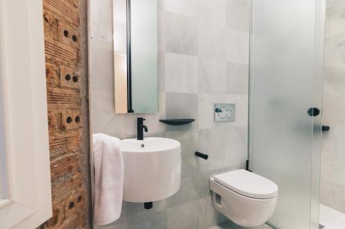 a white bathroom with a sink and a toilet at Moyua Apartment by People Rentals in Bilbao