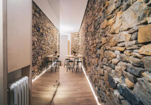 a room with a stone wall and tables at Moyua Apartment by People Rentals in Bilbao