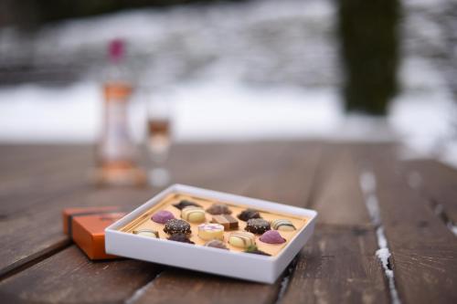 una caja de rosquillas cubiertas de chocolate sobre una mesa de madera en Horizont Panzio, en Odorheiu Secuiesc