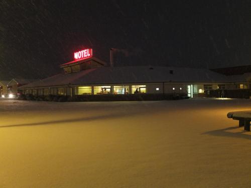 a night view of a building with a neon sign at Motel Spar 10 in Viborg