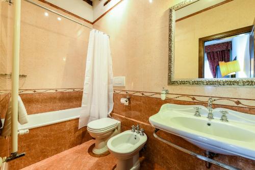 a bathroom with a sink and a toilet and a mirror at Casetta Rossa in Venice