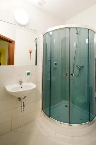 a bathroom with a glass shower and a sink at Hotel Gościniec Horyzont in Zemborzyce Tereszyńskie