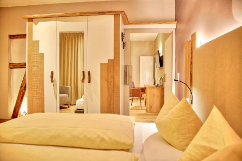 Flair Hotel Nieder في بيستفيغ: غرفة نوم مع سرير وغرفة معيشة