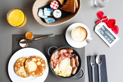 a table with plates of breakfast foods and a cup of coffee at Upper Diagonal in Barcelona