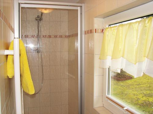 une douche avec rideau de douche jaune et une fenêtre dans l'établissement Ferienhaus Schrammsteinblick, à Bad Schandau