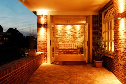 an open door with a bench on a brick building at Hotel Strandhof in Baltrum