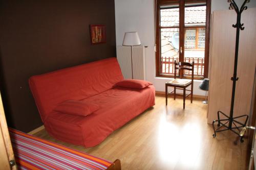 コルマールにあるAu Chasseurの窓付きのリビングルーム(オレンジ色のソファ付)