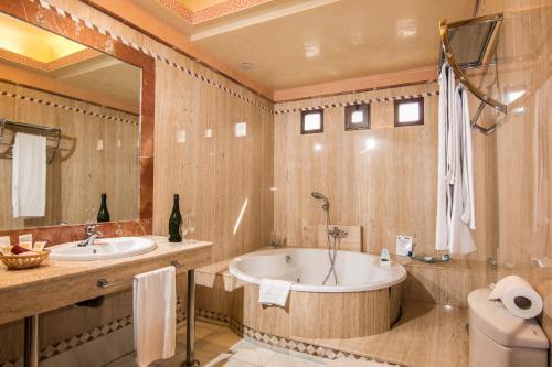 y baño con bañera, lavabo y aseo. en Hotel Abades Guadix, en Guadix