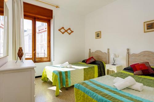 - une chambre avec 2 lits et une fenêtre dans l'établissement Macrina, à Tamariu