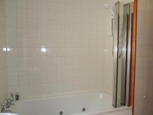a bathroom with a bath tub and a sink at Atlantic Bay Cottage in Clachan