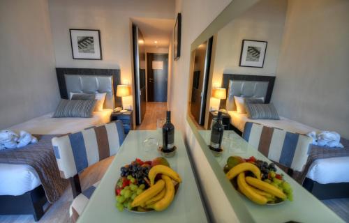 a room with two beds and a table with fruit on it at St. Julian's Bay Hotel in St Julian's