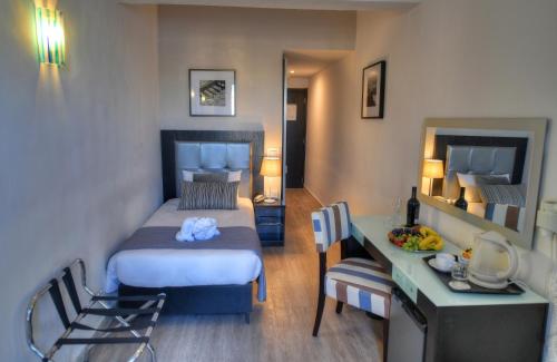 a bedroom with a bed and a desk in a room at St. Julian's Bay Hotel in St Julian's