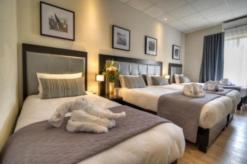 une chambre avec trois lits avec des animaux rembourrés dans l'établissement St. Julian's Bay Hotel, à San Ġiljan