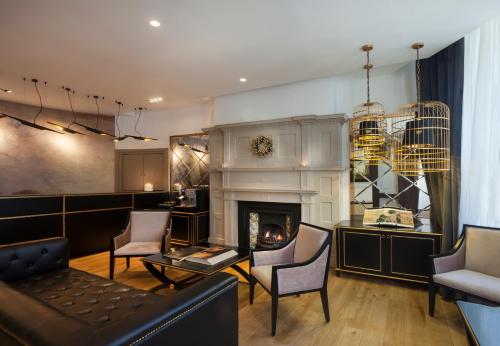 a living room with a fireplace and a couch and chairs at Nottingham Place Hotel in London