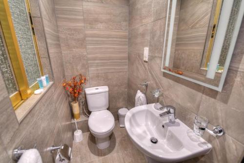 a bathroom with a white toilet and a sink at St. Julian's Bay Hotel in St Julian's