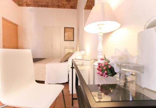 ローマにあるMachiavelli Suitesのテーブル(ランプ付)とベッド1台が備わる客室です。