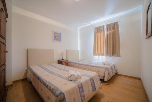 1 dormitorio con 2 camas y ventana en Marina Buzios by Garvetur, en Vilamoura